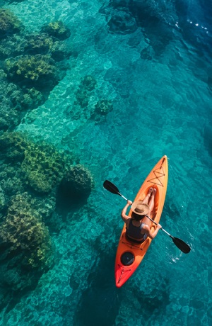 Person paddleboarding on clear turquoise water
